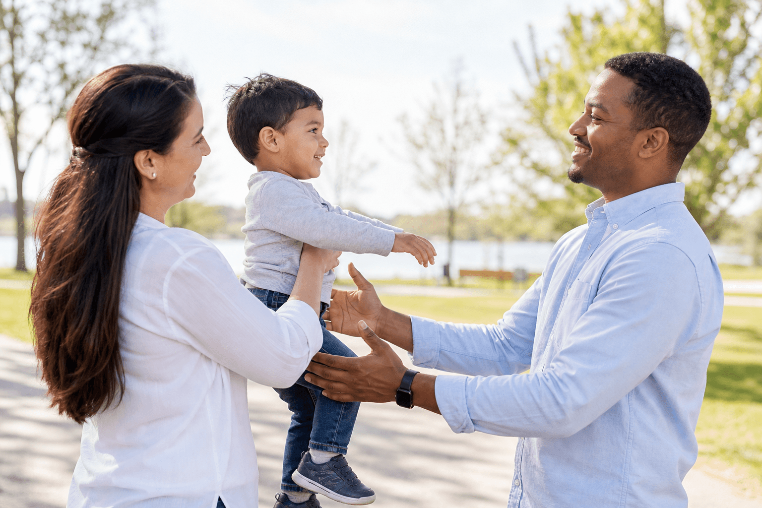 Co-parents peacefully exchanging care of their child outdoors